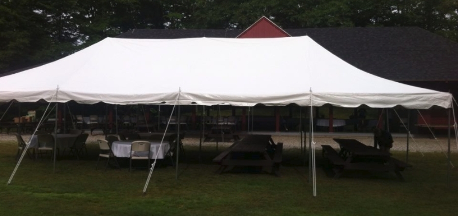 party tent over table and chairs in a field